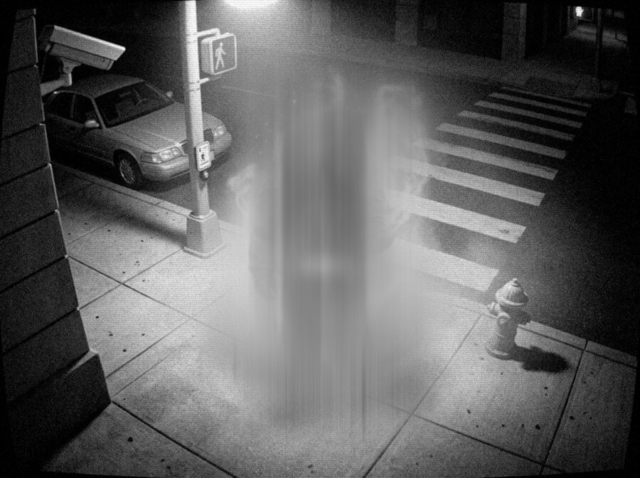 Monochrome security camera frame of a sidewalk at night, everything sharp except a tall vertical smear crossing it
